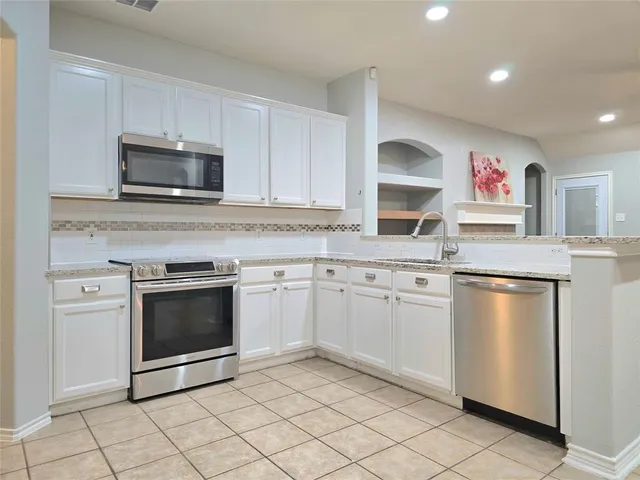 a kitchen with stainless steel appliances granite countertop a stove microwave and sink