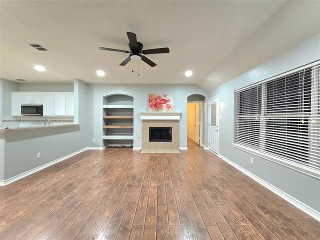 a view of an empty room with a window and fireplace