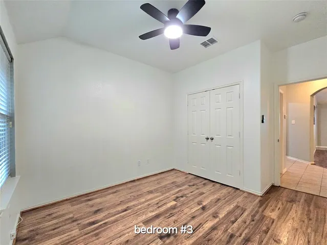 a view of empty room with wooden floor