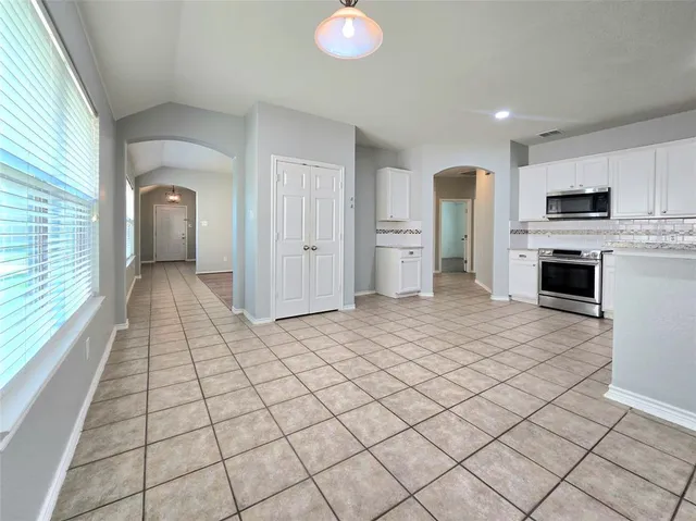 a view of a kitchen with microwave and refrigerator