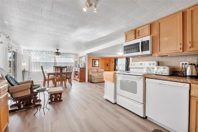 a kitchen with stainless steel appliances granite countertop a stove and white cabinets with wooden floor