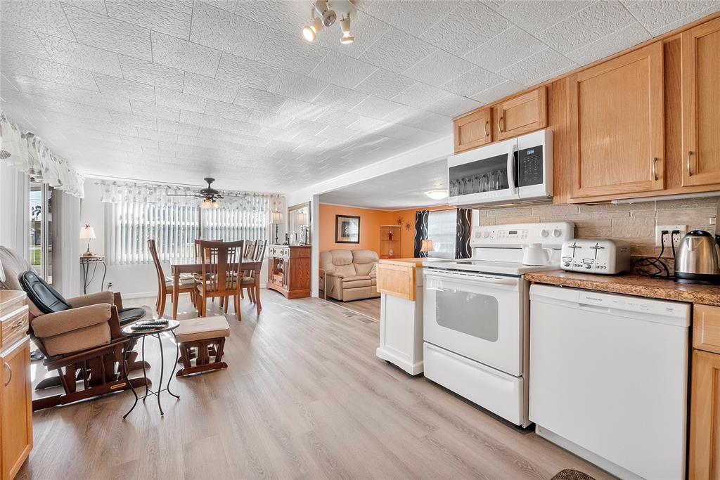8631 Southwest 20th Street Davie, FL 33324 - Photo 5 of 21 a kitchen with stainless steel appliances granite countertop a stove and white cabinets with wooden floor