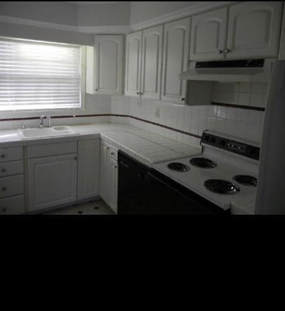 2040 Kings Gate Circle Southwest, Unit B Snellville, GA 30078 - Photo 3 of 7 a kitchen with a sink stove and cabinets