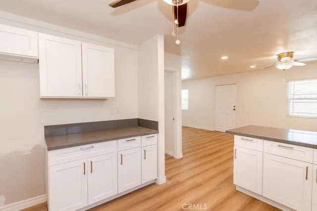 a kitchen with a sink cabinets and wooden floor
