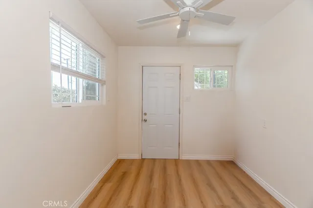 an empty room with a window and a fan