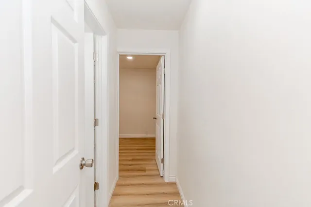 a view of a hallway with wooden floor and entryway