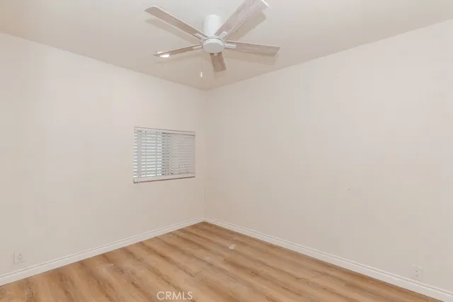an empty room with a window and a ceiling fan