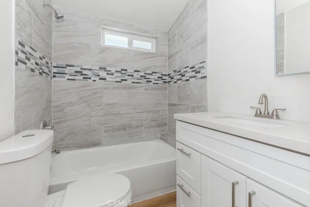 a bathroom with a sink toilet vanity and bathtub