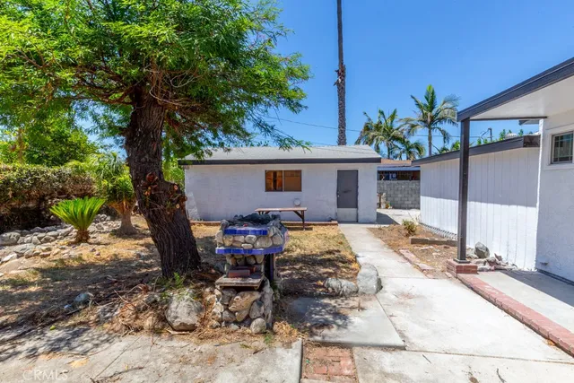a view of backyard with a table and chairs under an umbrella