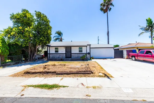 a front view of a house with a yard and potted plants