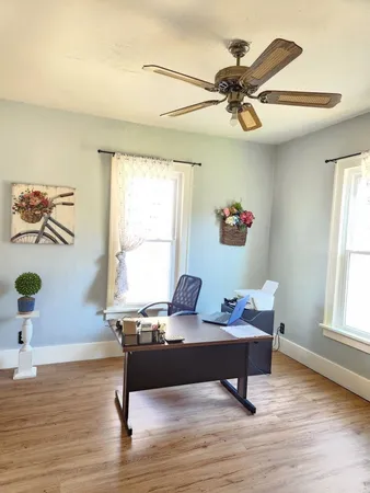 a view of a workspace with furniture and a window