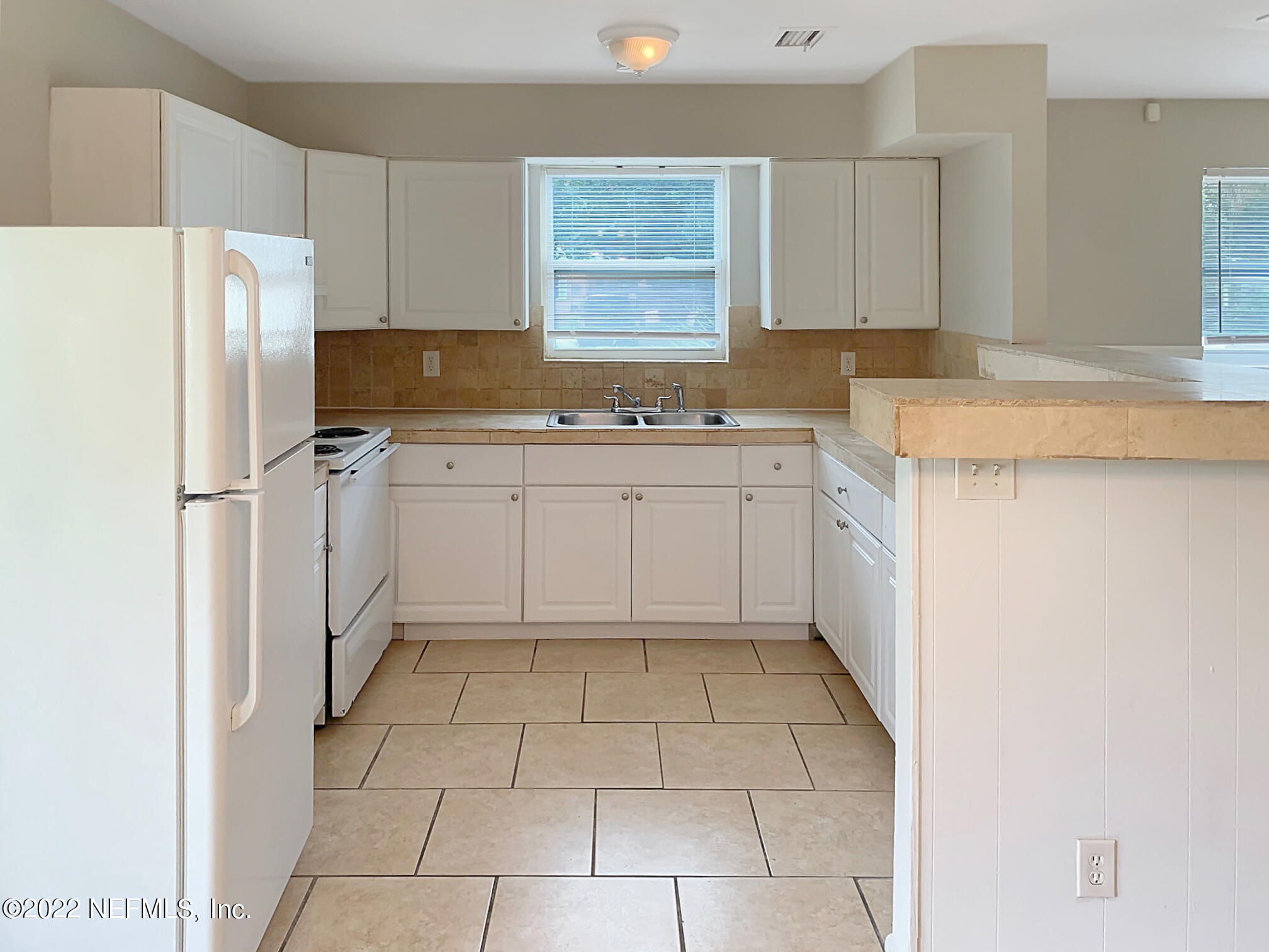 2950 Mansion Road Jacksonville, FL 32277 - Photo 16 of 30 a kitchen with a cabinets a refrigerator and a sink