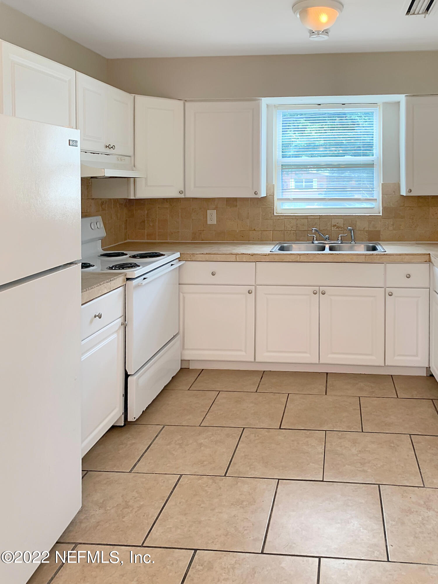 2950 Mansion Road Jacksonville, FL 32277 - Photo 19 of 30 a kitchen with granite countertop white cabinets and white appliances