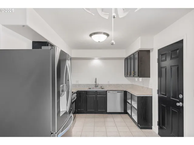 a kitchen with stainless steel appliances granite countertop a refrigerator and a sink