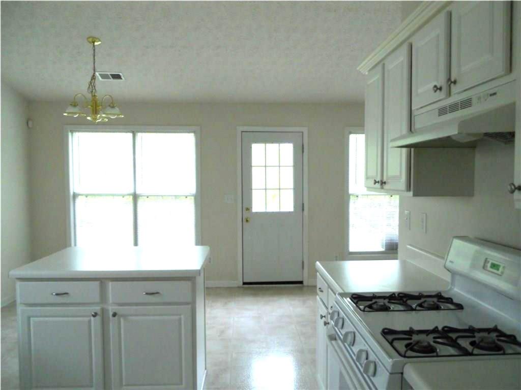 301 Yarbrough Court Dacula, GA 30019 - Photo 4 of 11 a kitchen with granite countertop a stove and a window