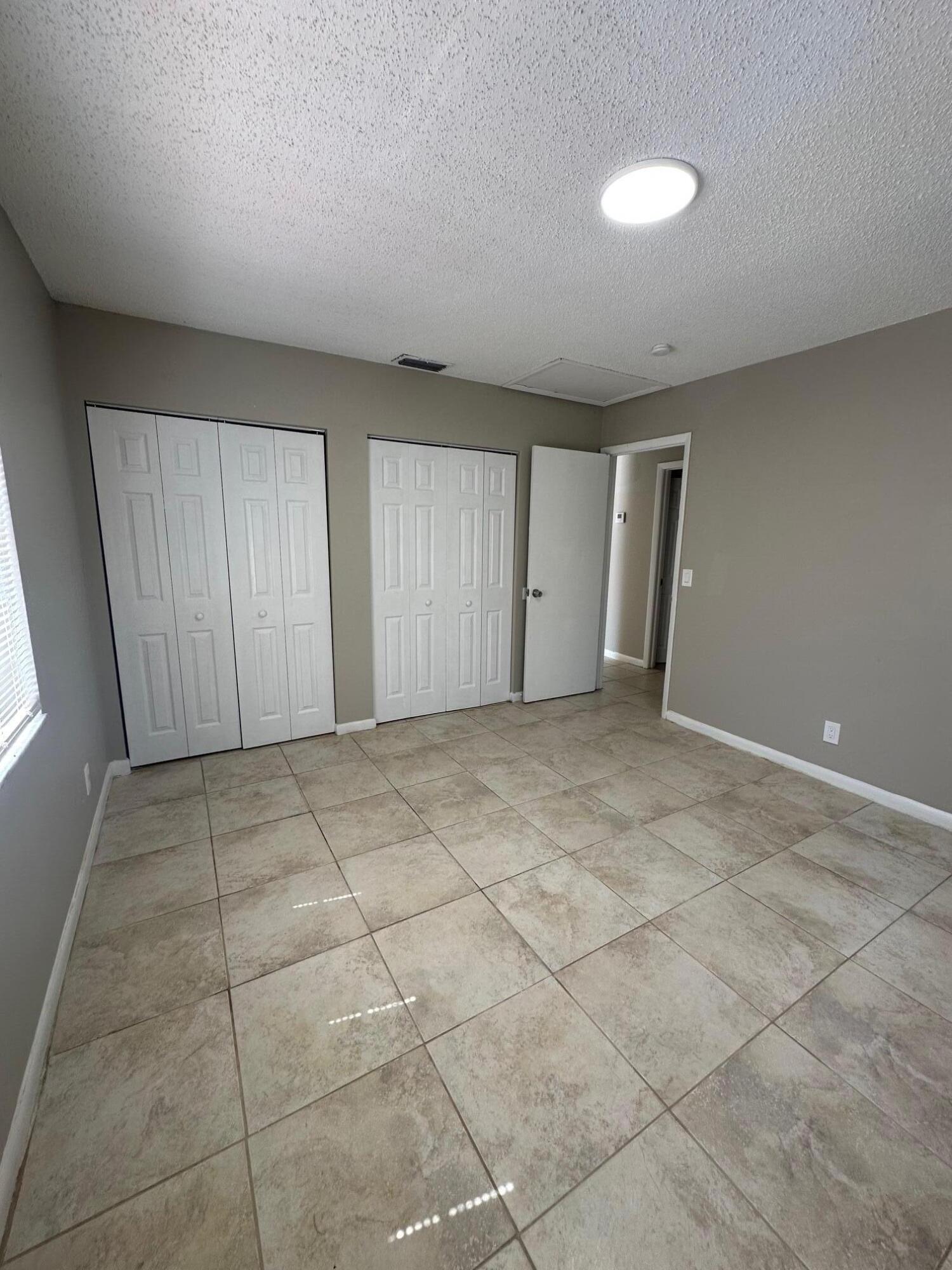 4810 Davis Road, Unit 4818 Lake Worth, FL 33461 - Photo 8 of 12 a view of an empty room and window