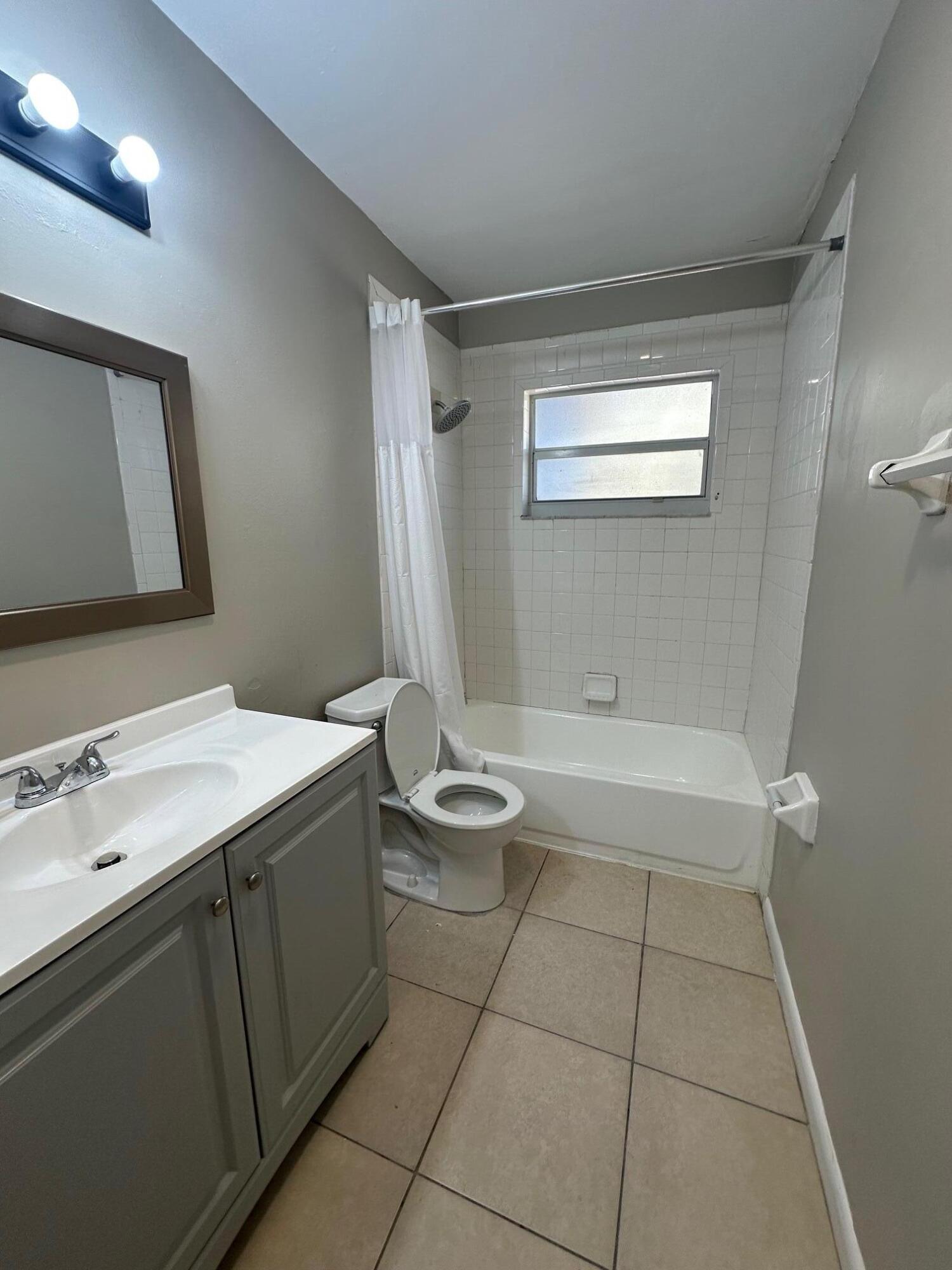 4810 Davis Road, Unit 4818 Lake Worth, FL 33461 - Photo 9 of 12 a bathroom with a granite countertop sink toilet and shower