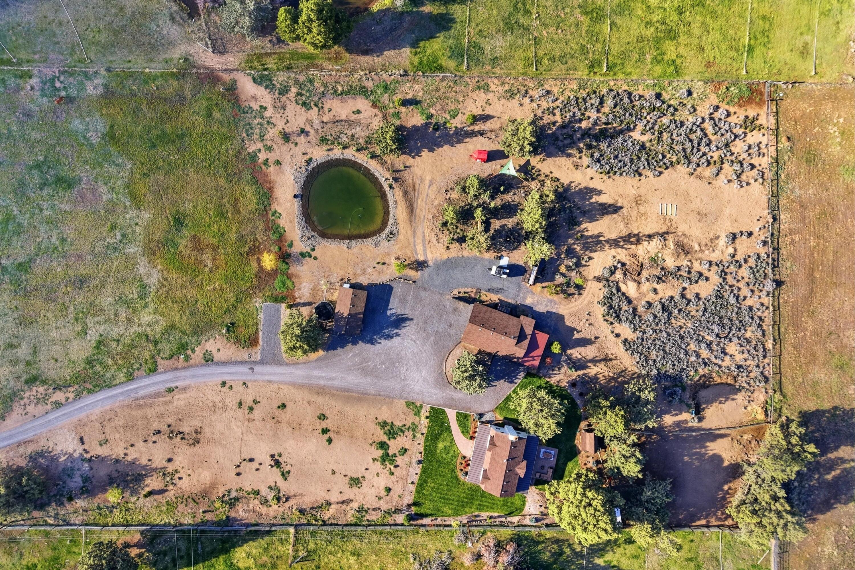 61280 Larsen Road Bend, OR 97702 - Photo 52 of 58 an aerial view of a house with a yard and black swimming pool