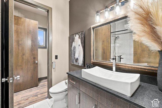 5936 Triple Crown Trail Oakley, UT 84055 - Photo 21 of 57 Wood-finish bathroom door, white rectangular vessel sink, dark wood-finish vanity with drawer storage, sleek chrome faucet, and contemporary vanity lighting