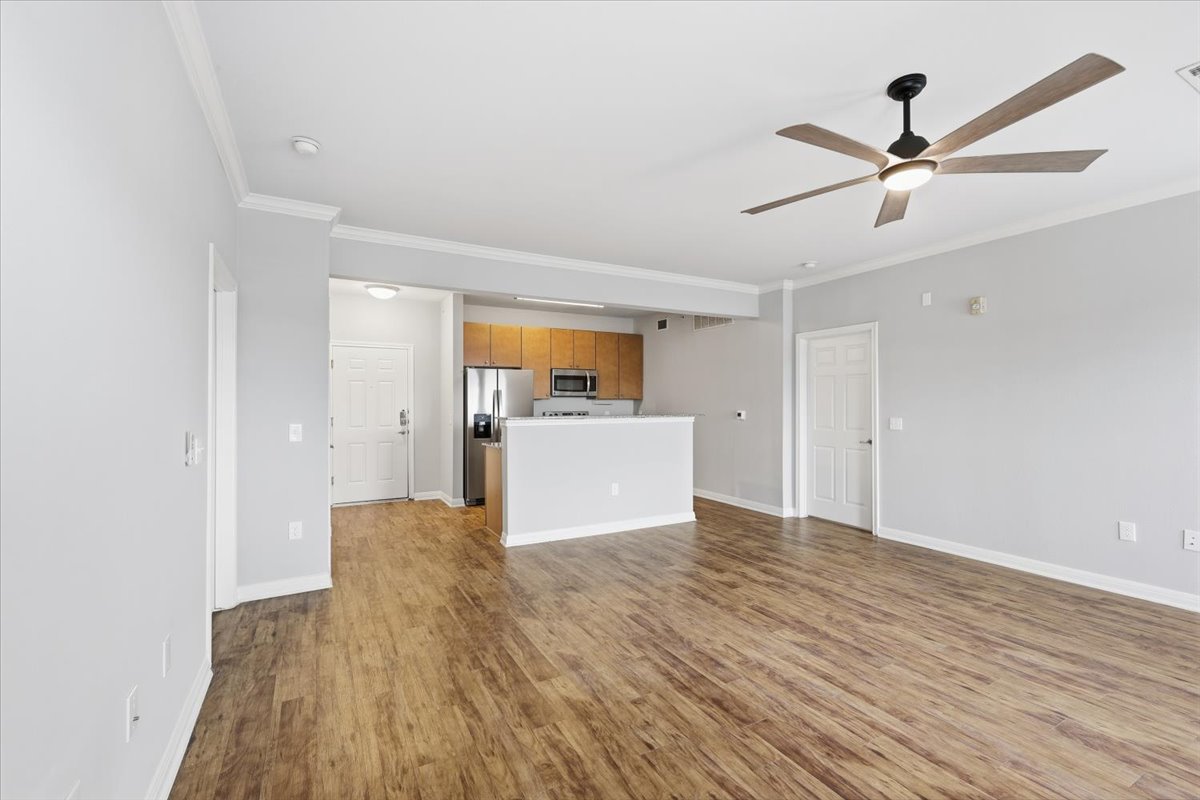 2502 Leon Street, Unit 414 Austin, TX 78705 - Photo 11 of 21 a view of a kitchen with wooden floor and a ceiling fan