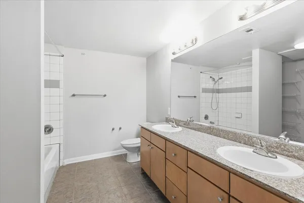 a spacious bathroom with a granite countertop sink toilet and shower