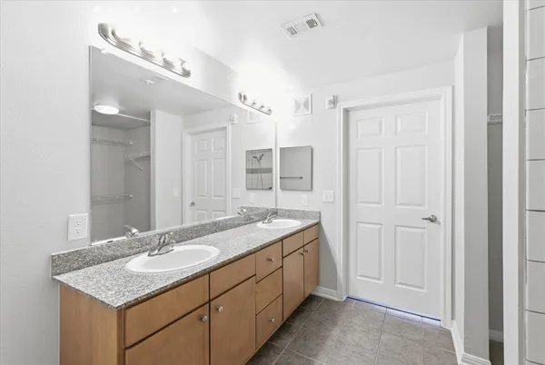 a bathroom with a granite countertop sink and a mirror