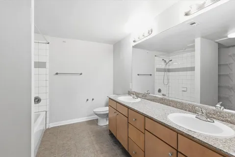 a spacious bathroom with a granite countertop sink toilet and shower