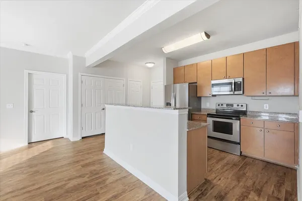 a kitchen with granite countertop a refrigerator and a stove top oven