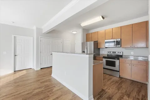 a kitchen with granite countertop a refrigerator and a stove top oven