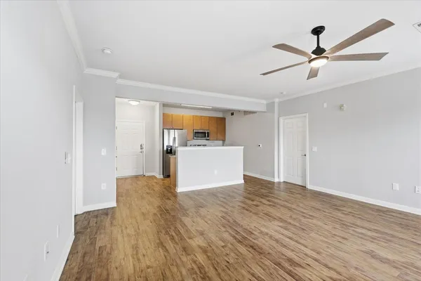 a view of a kitchen with wooden floor and a ceiling fan