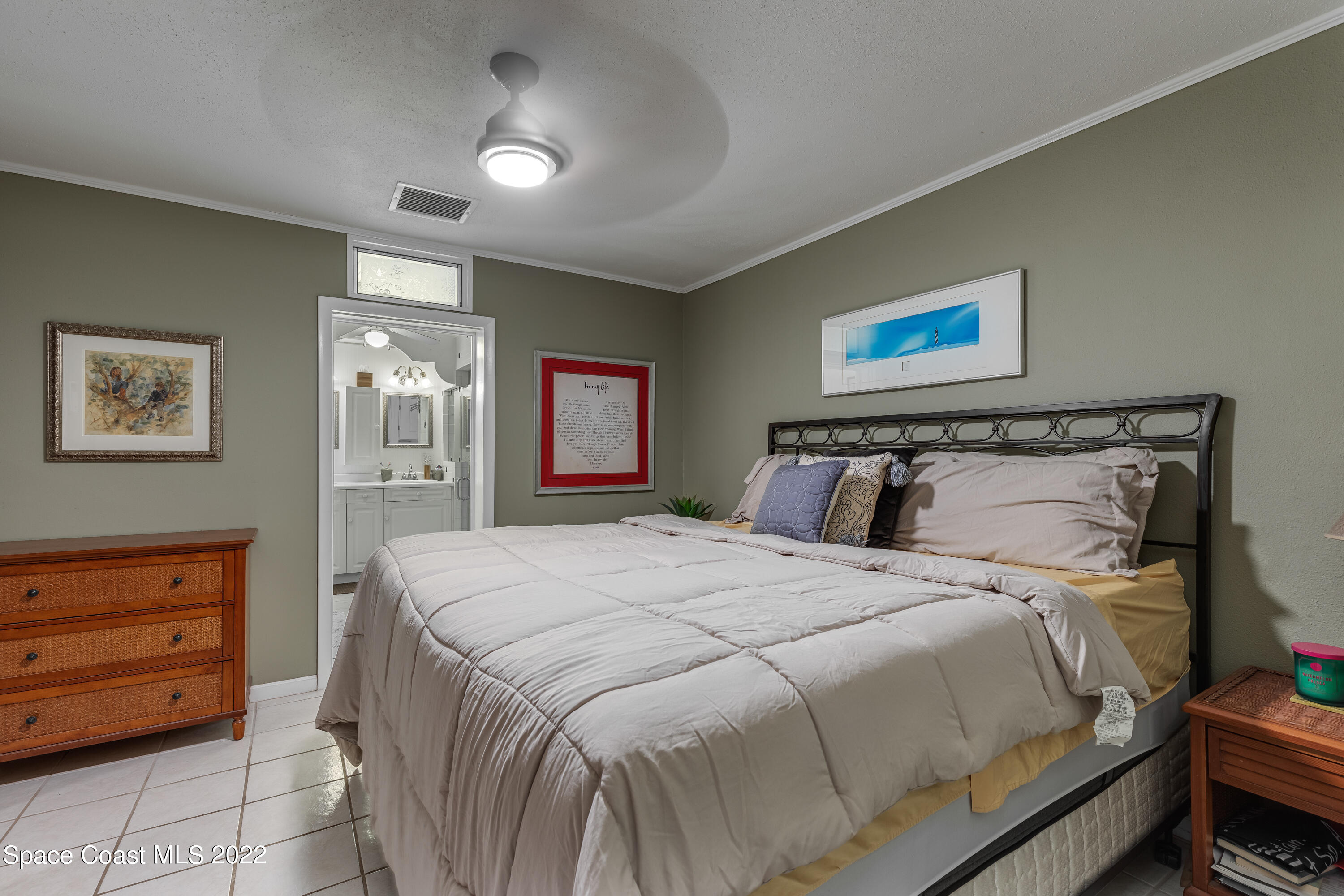 515 Oak Ridge Drive Indialantic, FL 32903 - Photo 14 of 34 a bedroom with a bed and a chandelier