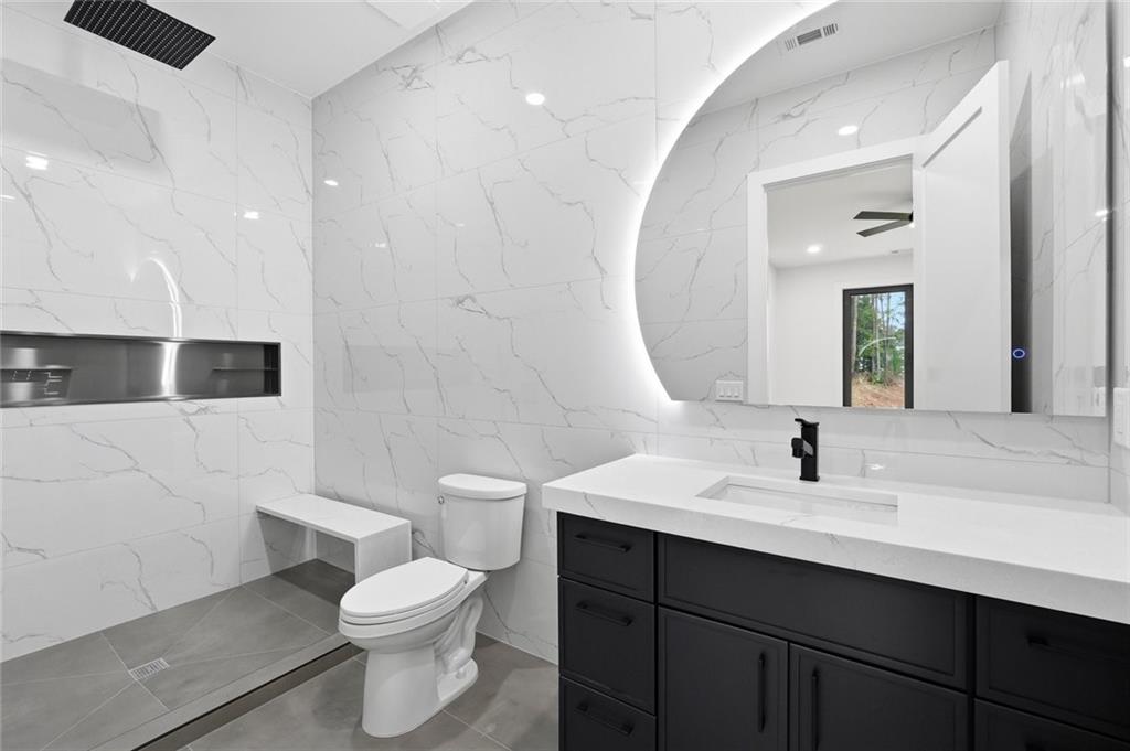 1563 Whitley Road Dacula, GA 30019 - Photo 33 of 44 a bathroom with a sink a toilet a mirror and shower
