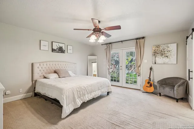 a view of a patio with table and chairs under an umbrella with a barbeque