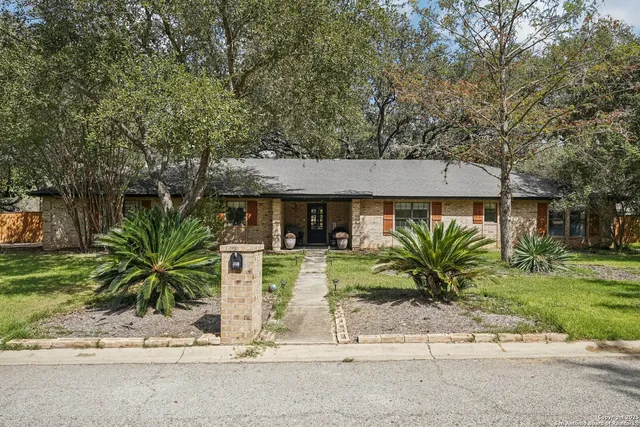 a bedroom with a bed a chandelier and a mirror