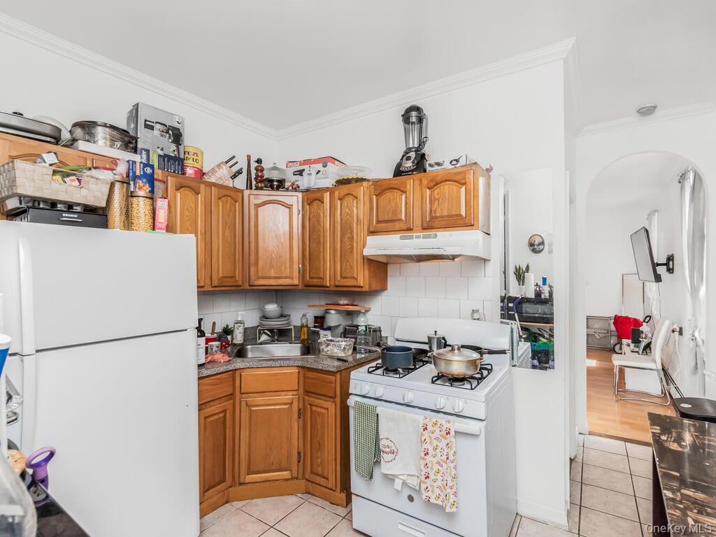 2108 Arthur Avenue Bronx, NY 10457 - Photo 6 of 12 a kitchen with stainless steel appliances granite countertop a refrigerator and a stove top oven