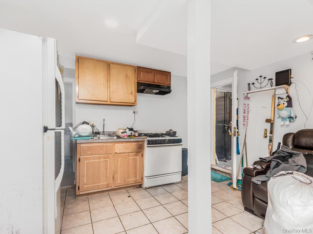 2108 Arthur Avenue Bronx, NY 10457 - Photo 9 of 12 a kitchen with stainless steel appliances granite countertop a refrigerator and a stove top oven