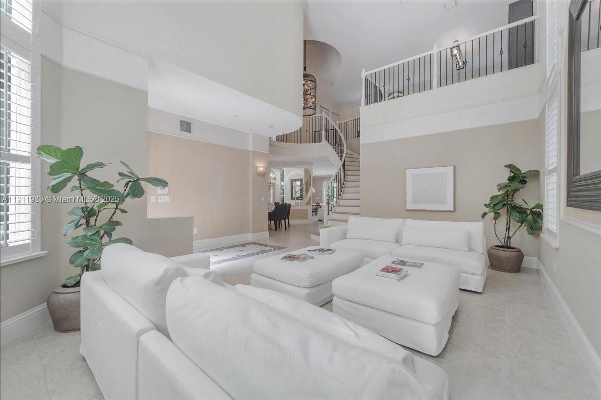 a living room with furniture flowerpot and a chandelier