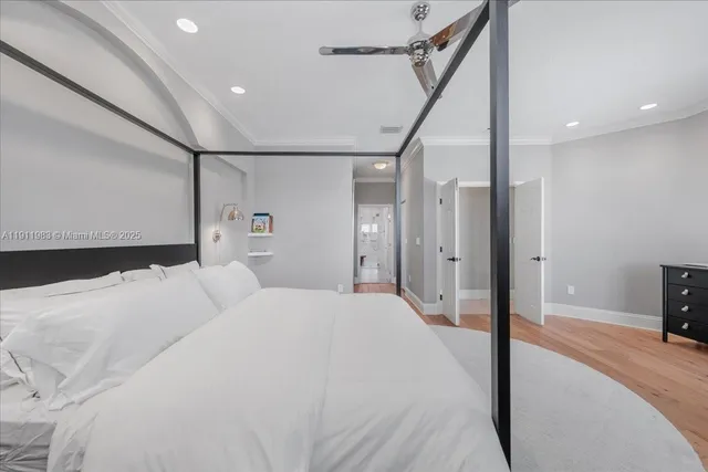 a view of a hallway to a livingroom with wooden floor and windows