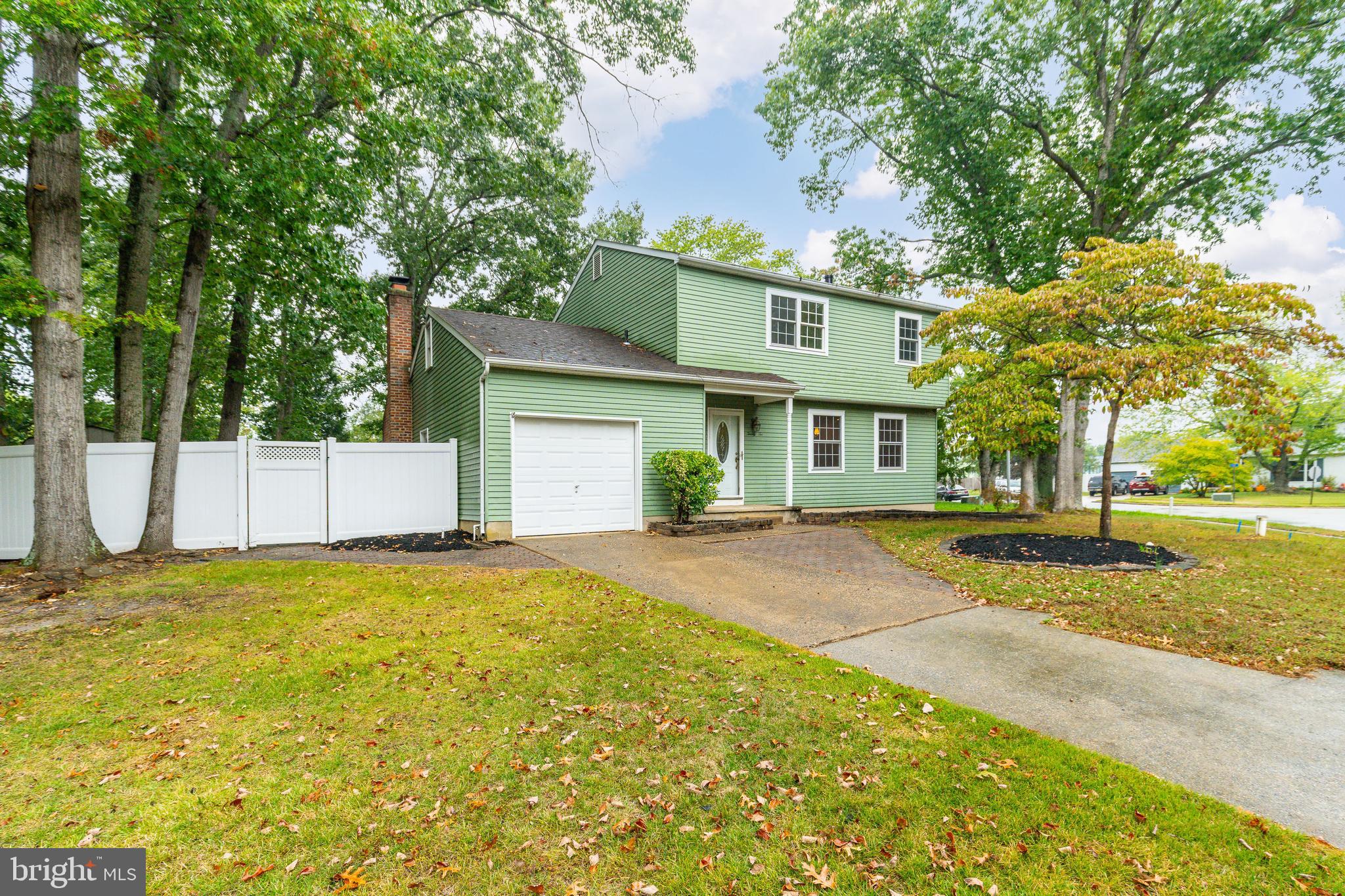 a view of a house with a backyard and a tree