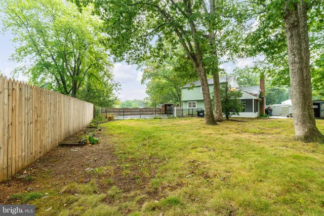 a backyard of a house with swimming pool and large trees