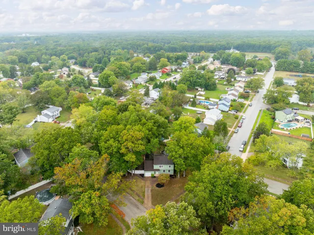 an aerial view of residential houses with outdoor space and trees