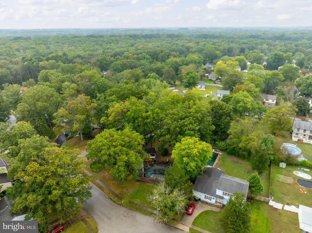 an aerial view of residential houses with outdoor space and trees