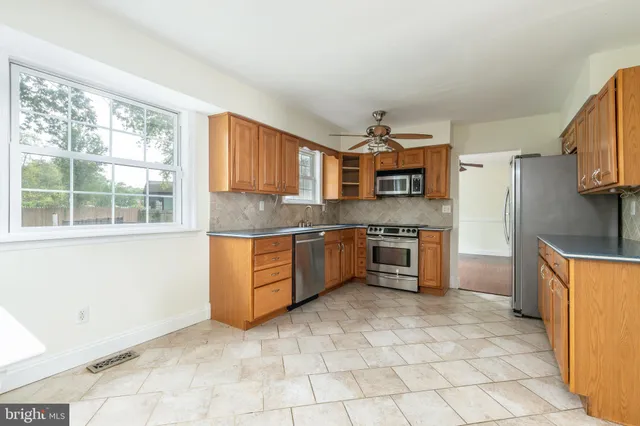 a kitchen with stainless steel appliances granite countertop a stove a sink and a refrigerator