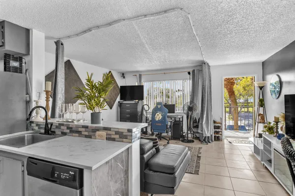 a living room with furniture a rug and a floor to ceiling window