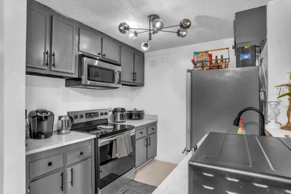 a kitchen with stainless steel appliances granite countertop a sink a stove and cabinets