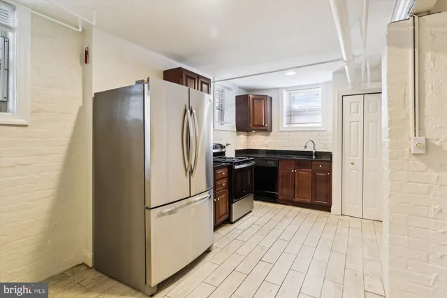 a kitchen with stainless steel appliances granite countertop a refrigerator and a sink