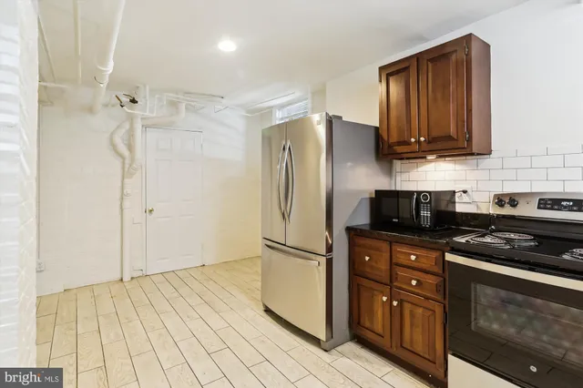 a kitchen with stainless steel appliances granite countertop a refrigerator and a stove top oven