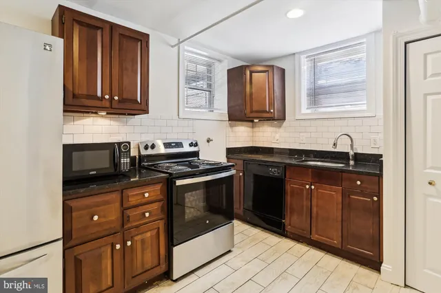 a kitchen with stainless steel appliances granite countertop a sink stove and oven