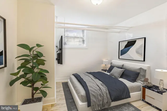 a bedroom with bed and a potted plant