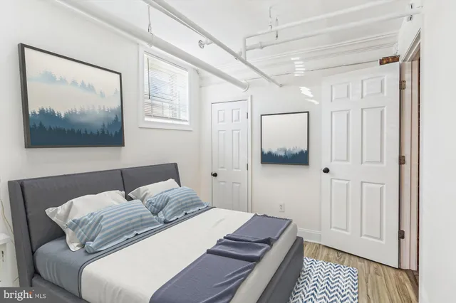 a bedroom with a bed and a painting on the wall